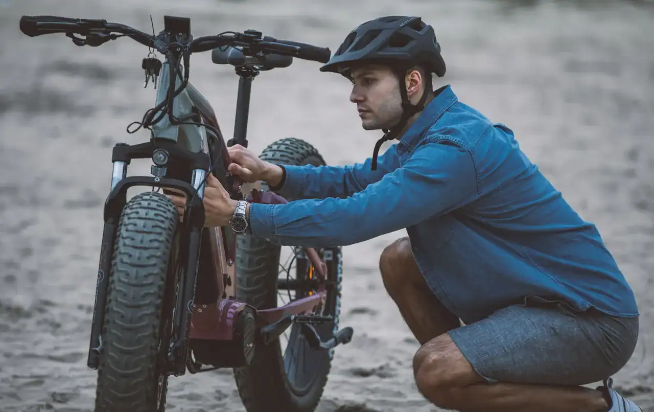 manutenção de bicicleta elétrica: ciclista realizando inspeção em e-bike antes de pedalar